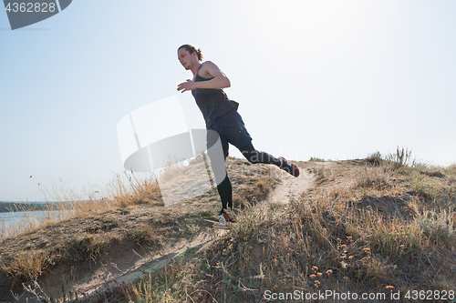 Image of Running sport. Man runner sprinting outdoor in scenic nature. Fit muscular male athlete training trail running for marathon run.