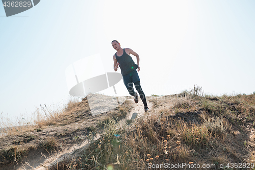 Image of Running sport. Man runner sprinting outdoor in scenic nature. Fit muscular male athlete training trail running for marathon run.