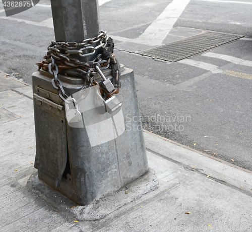 Image of Heavy metal chain and padlock wound around pole