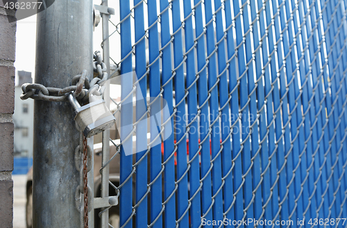 Image of Heavy-duty padlock and chain on blue security gate