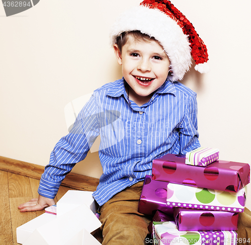 Image of little cute boy with Christmas gifts at home. close up emotional