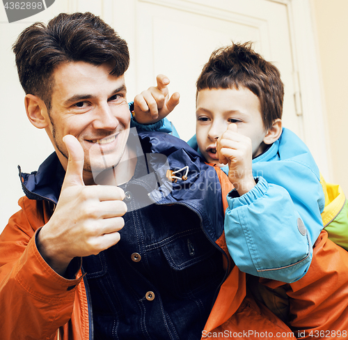 Image of young handsome father with his son fooling around at home, lifes