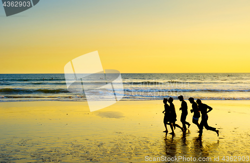 Image of People running on the beach