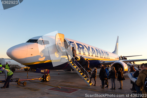 Image of People boarding on Ryanair Jet commercial airplane on Valencia airport at sunset.