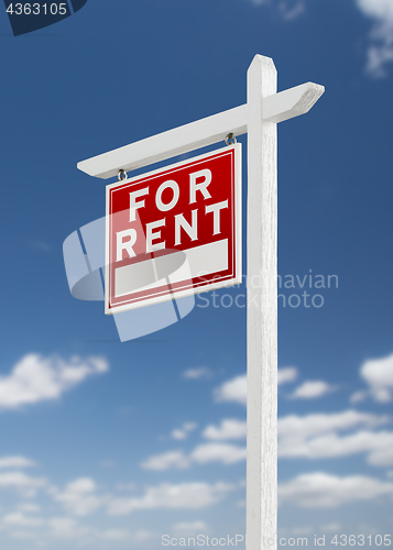 Image of Left Facing For Rent Real Estate Sign on a Blue Sky with Clouds.