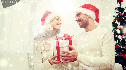 Image of happy couple at home with christmas gift box