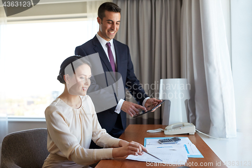 Image of business team with papers working at hotel room