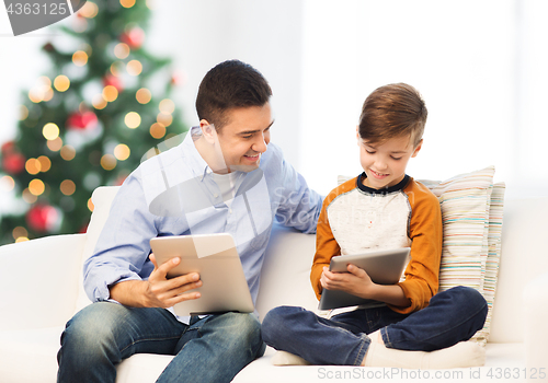 Image of happy father and son with tablet pc at christmas