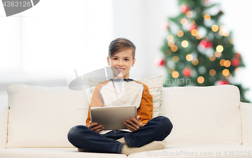 Image of smiling boy with tablet pc at home at christmas