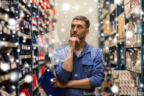 Image of auto mechanic with clipboard at car workshop