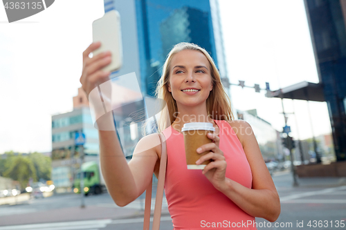 Image of woman with coffee taking selfie by smartphone