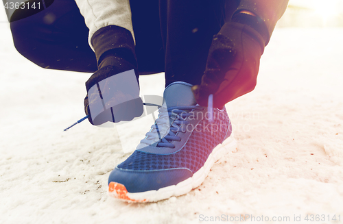 Image of close up of man tying shoe lace in winter outdoors