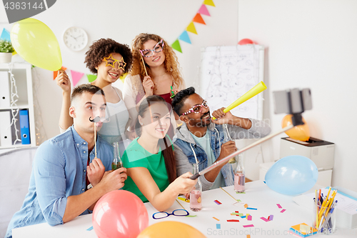 Image of happy team taking selfie at office party