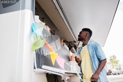 Image of african american man with drink at food truck