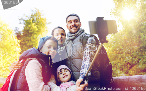 Image of family with backpacks taking selfie and hiking