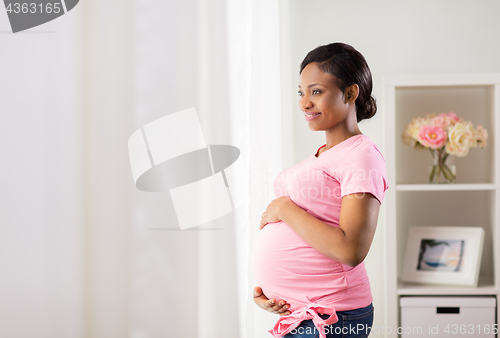 Image of happy pregnant woman with big belly at home