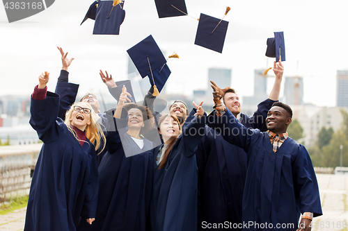 Image of happy graduates or students throwing mortar boards