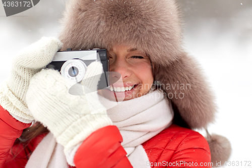 Image of happy woman with film camera outdoors in winter