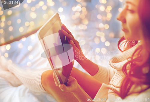 Image of young woman with tablet pc in bed at home