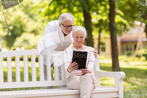 Image of happy senior couple with tablet pc at summer park