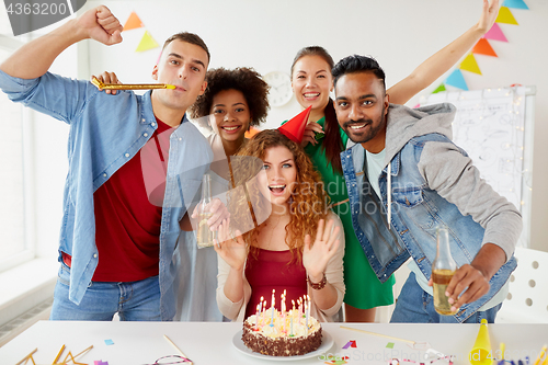 Image of happy coworkers with cake at office birthday party