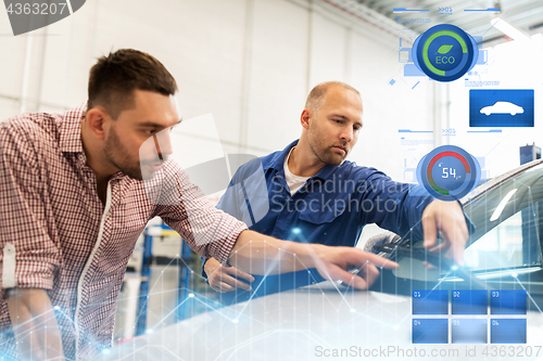 Image of auto mechanic with clipboard and man at car shop