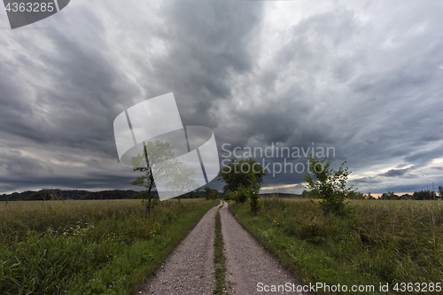 Image of Dirt road and the dark cloudy sky