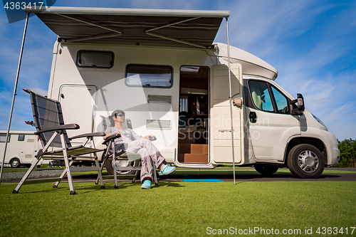 Image of Woman resting near motorhomes in nature. Family vacation travel,