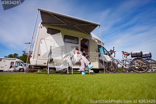 Image of Woman resting near motorhomes in nature. Family vacation travel,