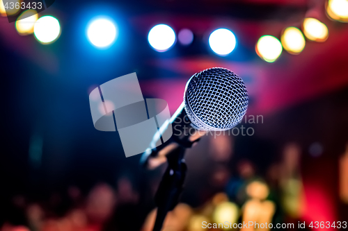 Image of Microphone on stage against a background of auditorium.