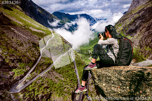 Image of Nature photographer tourist with camera shoots while standing on