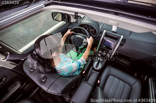 Image of Woman behind the wheel of a car.