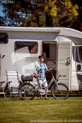 Image of Woman on electric bike resting at the campsite VR Caravan car Va