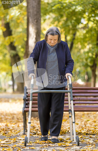 Image of Woman with walker walking outdoors