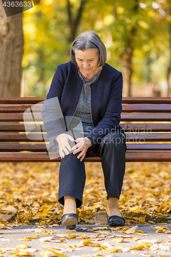 Image of Senior woman having knee pain walking in park