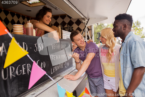 Image of seller showing menu to customers at food truck