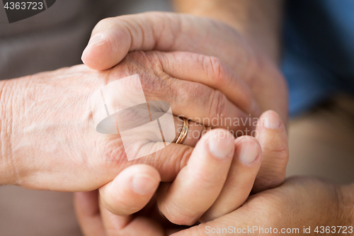 Image of close up of senior couple holding hands