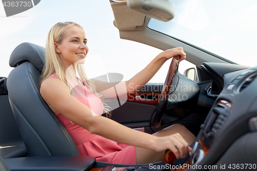 Image of happy young woman in convertible car