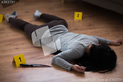 Image of dead woman body lying on floor at crime scene