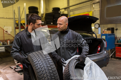 Image of auto mechanics changing car tires at workshop