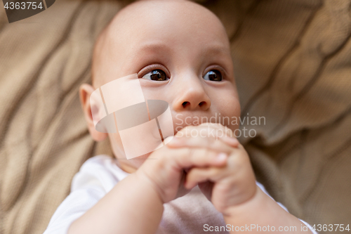 Image of close up of sweet little baby boy lying on blanket