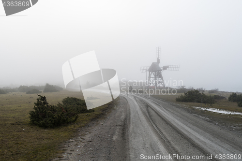 Image of Old windmill by roadside in the mist