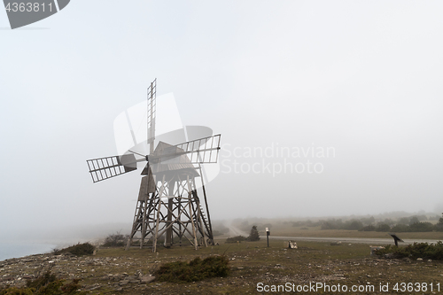 Image of Old windmill in a misty landscape