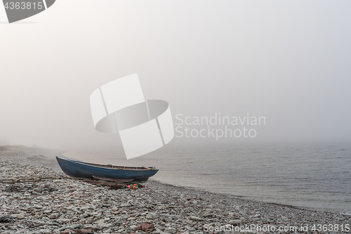 Image of Lone landed rowboat by seaside