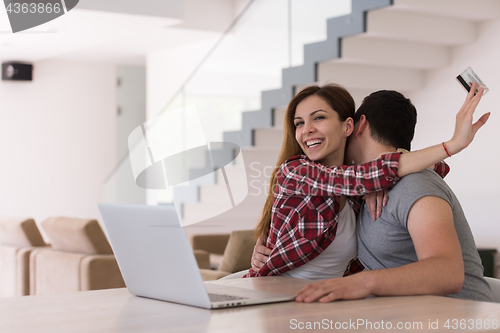 Image of happy young couple buying online