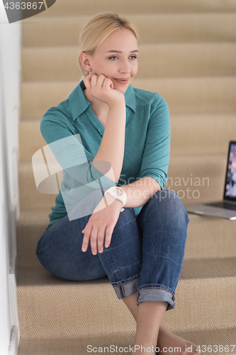 Image of portrait of a young beautiful woman on the stairs