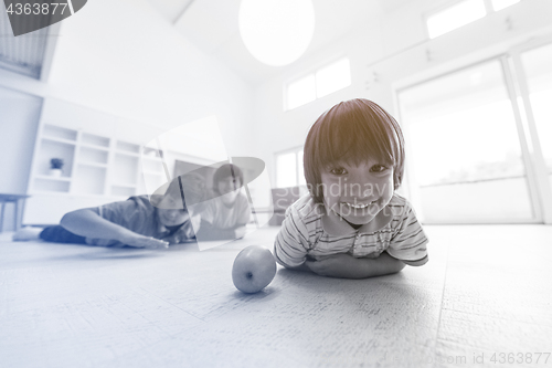 Image of boys having fun with an apple on the floor