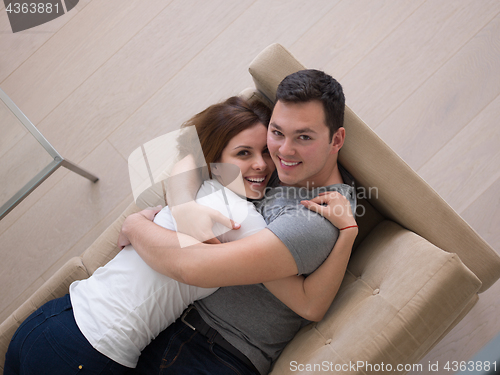 Image of young handsome couple hugging on the sofa