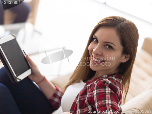 Image of couple relaxing at  home with tablet and laptop computers