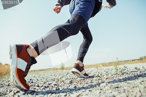 Image of Running sport. Man runner sprinting outdoor in scenic nature. Fit muscular male athlete training trail running for marathon run.